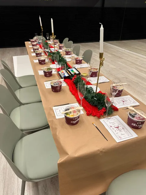 Mesa larga decorada con velas doradas, boles de acai y copas de champán para el evento
